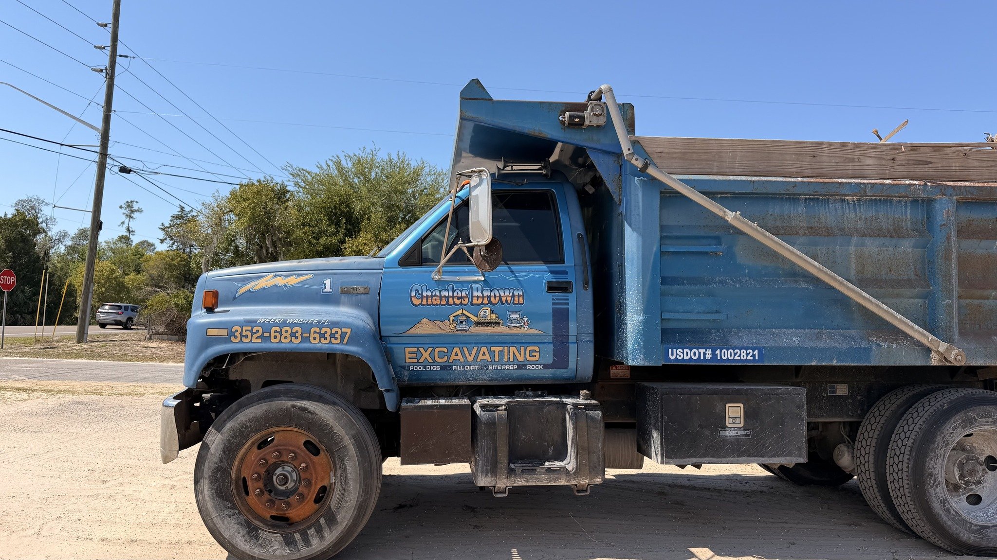 Charles Brown Excavating blue GMC dump truck on the road — Weeki Wachee FL